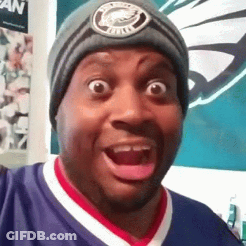 A Man Wearing A Beanie Is Making A Funny Face . GIF