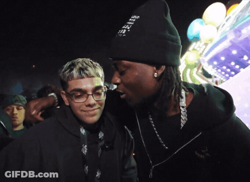 A Man Wearing A Beanie That Says " I Love You " Talks To Another Man GIF