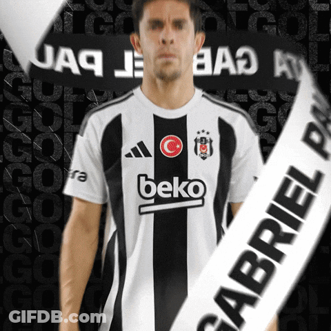A Man Wearing A Beko Shirt Stands In Front Of A Black Background GIF