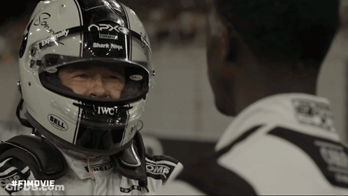 A Man Wearing A Bell Helmet Looks At Another Man GIF