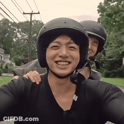 A Man Wearing A Bell Helmet Smiles With Another Man GIF