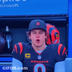 A Man Wearing A Bengals Jersey Is Sitting In Front Of A Microsoft Advertisement GIF