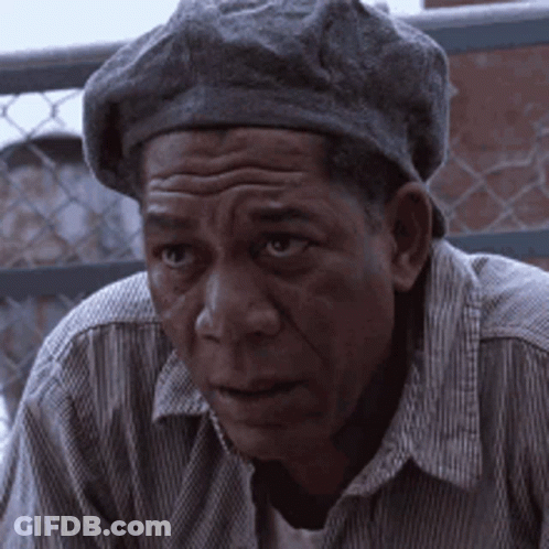A Man Wearing A Beret And A Striped Shirt Looks At The Camera GIF