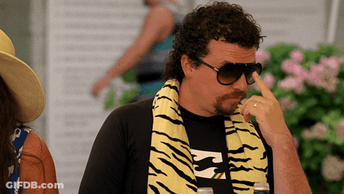 A Man Wearing A Billabong Shirt And A Tiger Print Scarf GIF
