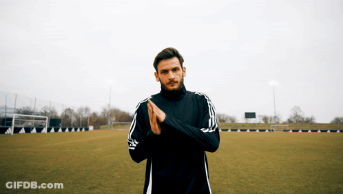 A Man Wearing A Black Adidas Jacket Is Standing On A Soccer Field GIF