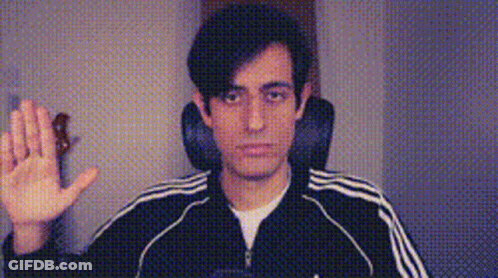 A Man Wearing A Black Adidas Jacket Is Waving His Hand In Front Of A Camera . GIF