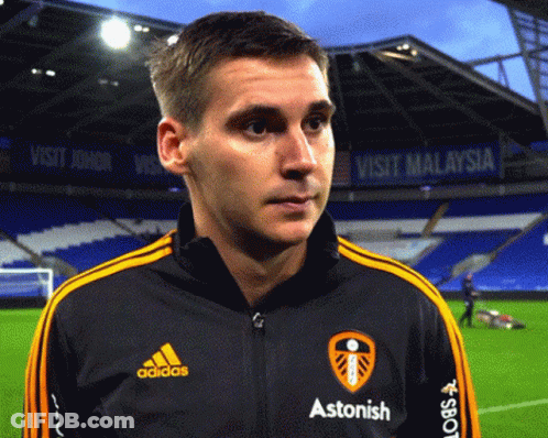 A Man Wearing A Black Adidas Jacket With Yellow Stripes GIF