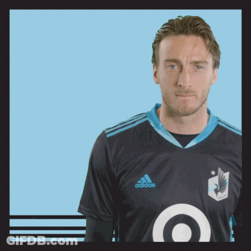 A Man Wearing A Black Adidas Shirt With A Blue Target On The Front GIF