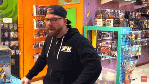 A Man Wearing A Black Aew Hoodie Is Standing In A Store GIF