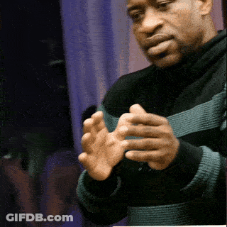 A Man Wearing A Black And Green Striped Sweater Holds His Hands Together GIF