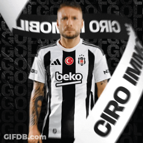 A Man Wearing A Black And White Beko Shirt Stands In Front Of A Black Background GIF