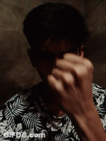 A Man Wearing A Black And White Floral Shirt Looks Down GIF
