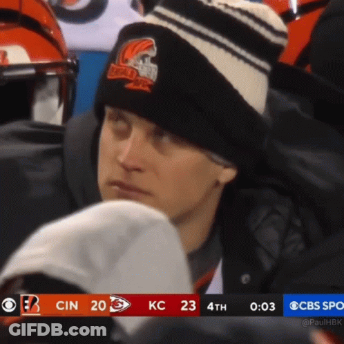 A Man Wearing A Black And White Striped Hat Watches A Football Game On Cbs GIF