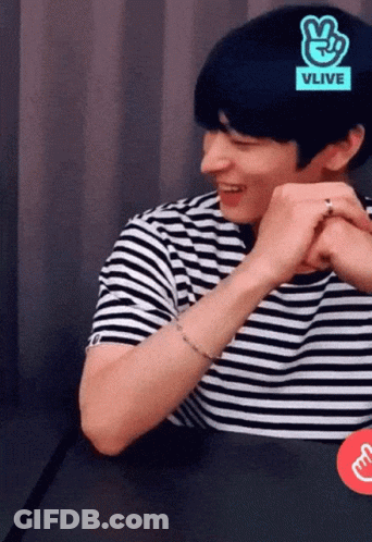 A Man Wearing A Black And White Striped Shirt With A Vlive Logo On His Head GIF
