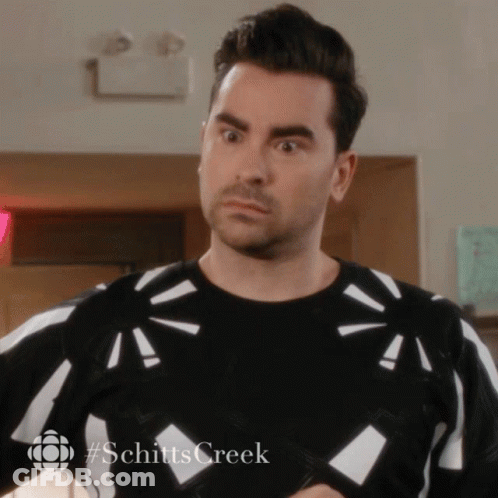 A Man Wearing A Black And White Sweater With #Schitts Creek On The Bottom GIF