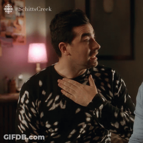 A Man Wearing A Black And White Sweater With #Schitts Creek Written On The Bottom GIF