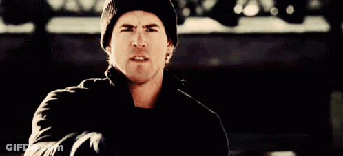 A Man Wearing A Black Beanie And A Black Jacket Is Pointing At The Camera GIF