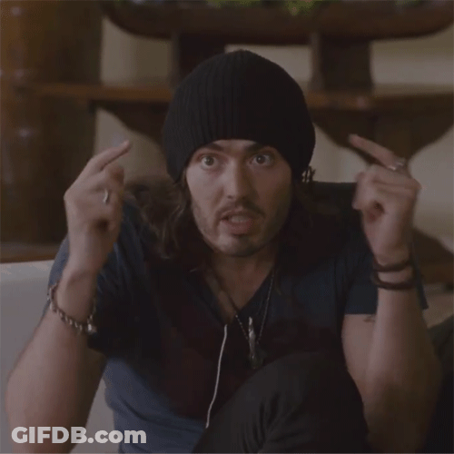 A Man Wearing A Black Beanie Is Making A Surprised Face With His Hands In The Air GIF