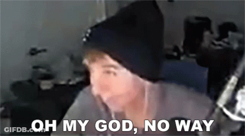 A Man Wearing A Black Beanie Is Sitting In Front Of A Microphone . GIF