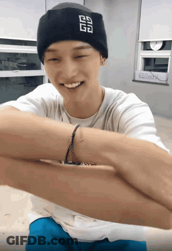 A Man Wearing A Black Beanie With The Letter G On It Smiles GIF