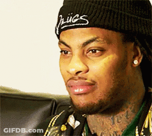 A Man Wearing A Black Beanie With The Word Hugs On It GIF