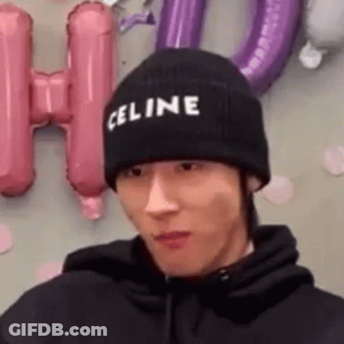 A Man Wearing A Black Celine Beanie Is Making A Funny Face . GIF