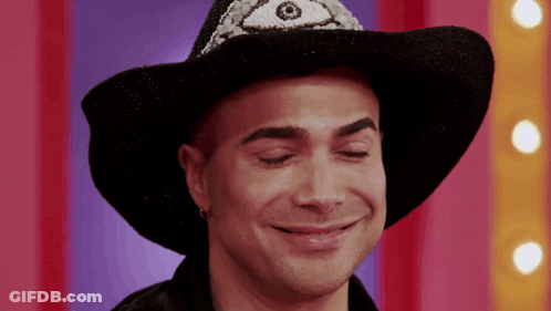 A Man Wearing A Black Cowboy Hat With A Third Eye On It GIF