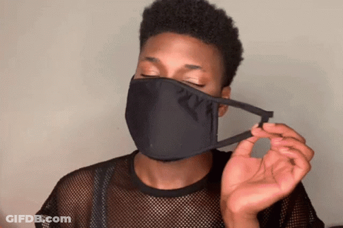 A Man Wearing A Black Face Mask Is Holding A Piece Of Fabric GIF