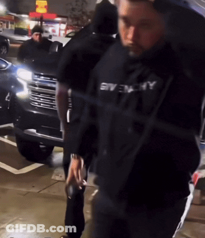 A Man Wearing A Black Givenchy Shirt Is Walking GIF