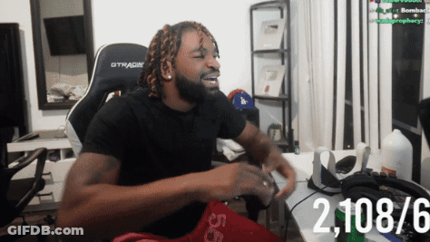 A Man Wearing A Black Gtracing Chair Is Sitting At A Desk GIF