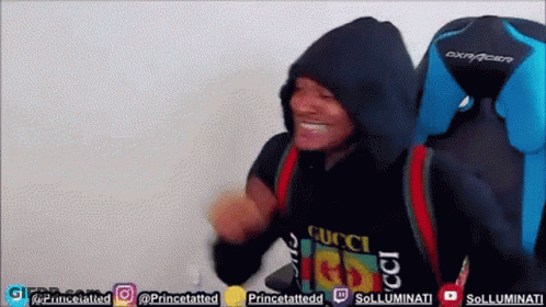 A Man Wearing A Black Gucci Shirt Is Sitting In A Blue Chair GIF