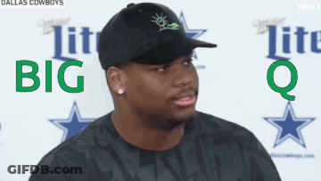 A Man Wearing A Black Hat And A Black Shirt Is Standing In Front Of A Sign That Says Dallas Cowboys GIF
