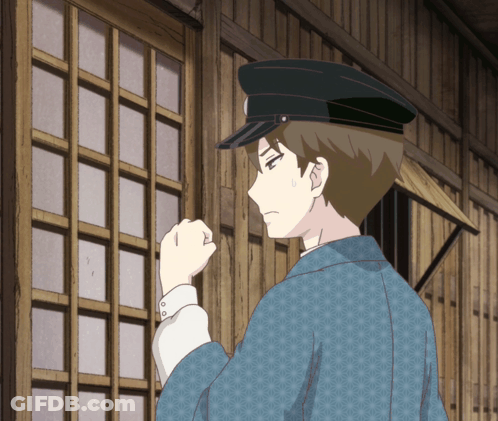 A Man Wearing A Black Hat And A Blue Jacket Stands In Front Of A Wooden Wall GIF