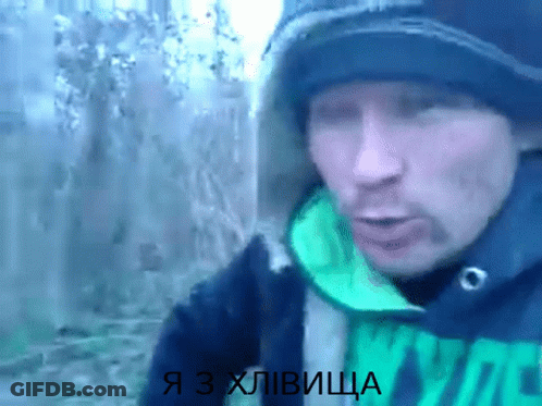 A Man Wearing A Black Hat And A Green Jacket With The Words Я З Хлівица On The Bottom GIF
