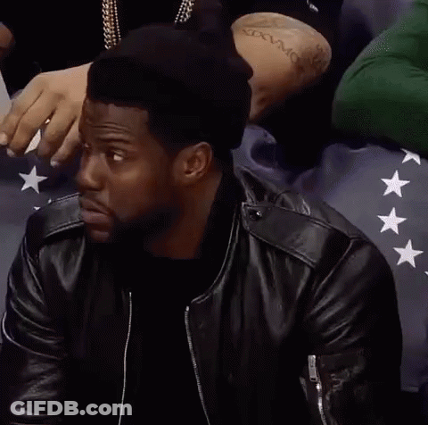 A Man Wearing A Black Hat And A Leather Jacket Is Sitting In A Crowd . GIF