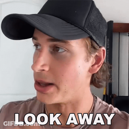 A Man Wearing A Black Hat And A Necklace Says Look Away GIF