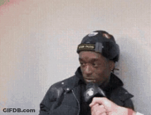 A Man Wearing A Black Hat Is Being Interviewed By A Reporter GIF
