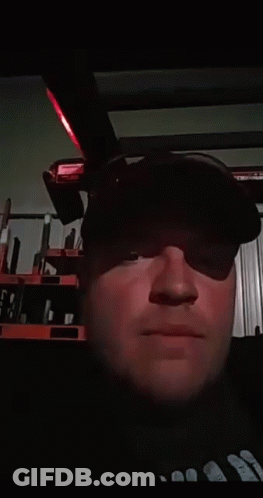 A Man Wearing A Black Hat Is Blowing A Kiss At The Camera GIF
