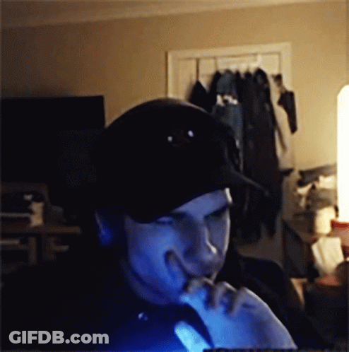 A Man Wearing A Black Hat Is Looking At A Computer Screen GIF