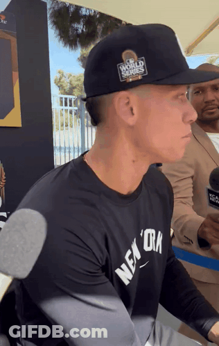 A Man Wearing A Black Hat That Says World Series GIF