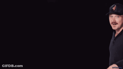 A Man Wearing A Black Hat With A Woman On It Making A Peace Sign GIF