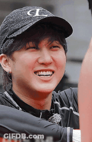 A Man Wearing A Black Hat With The Letter L On It Smiles GIF