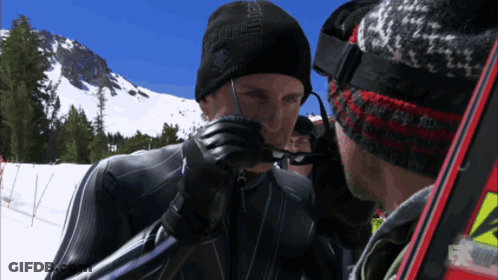 A Man Wearing A Black Hat With The Word Eagle On It Talks To Another Man GIF