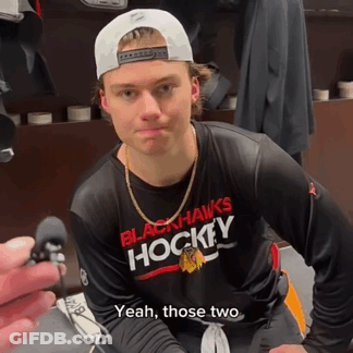 A Man Wearing A Black Hawks Hockey Shirt GIF