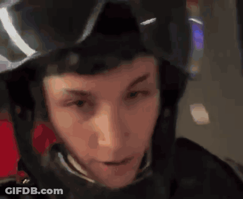 A Man Wearing A Black Helmet And Goggles Looks At The Camera GIF