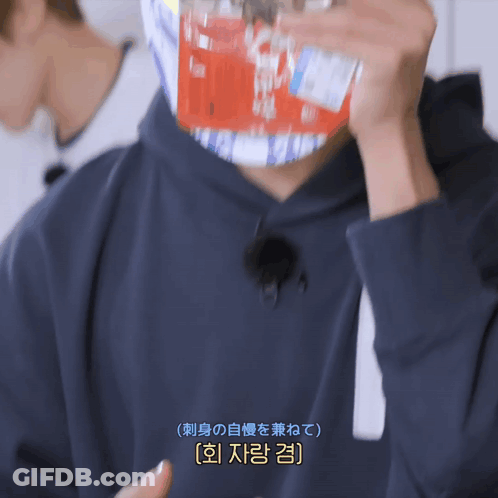 A Man Wearing A Black Hoodie Is Holding A Bottle Of Soda In Front Of His Face GIF