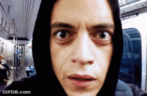 A Man Wearing A Black Hoodie Is Looking At The Camera With A Surprised Look On His Face GIF