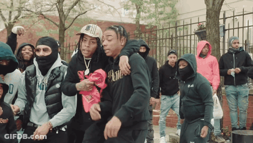 A Man Wearing A Black Hoodie With The Word Kill On It Stands In A Crowd Of People GIF