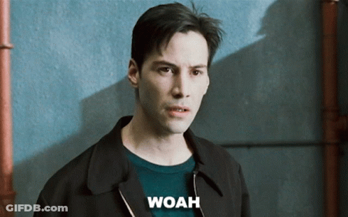 A Man Wearing A Black Jacket And A Green Sweater Has The Word Woah Above His Head GIF