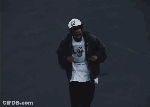 A Man Wearing A Black Jacket And A White Shirt With A Picture On It GIF